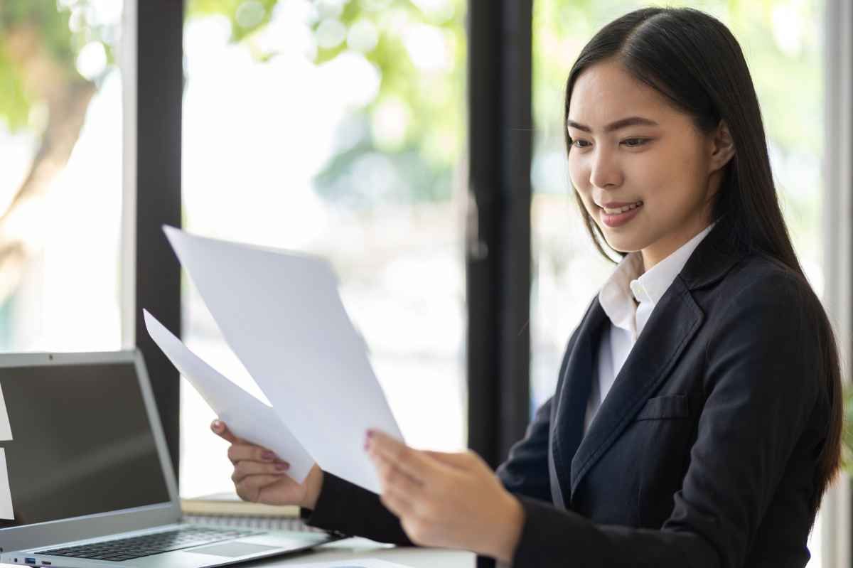 Ilustrasi seorang fresh graduate tampak bahagia setelah menerima surat referensi kerja dari atasan. (Sumber: Envato)