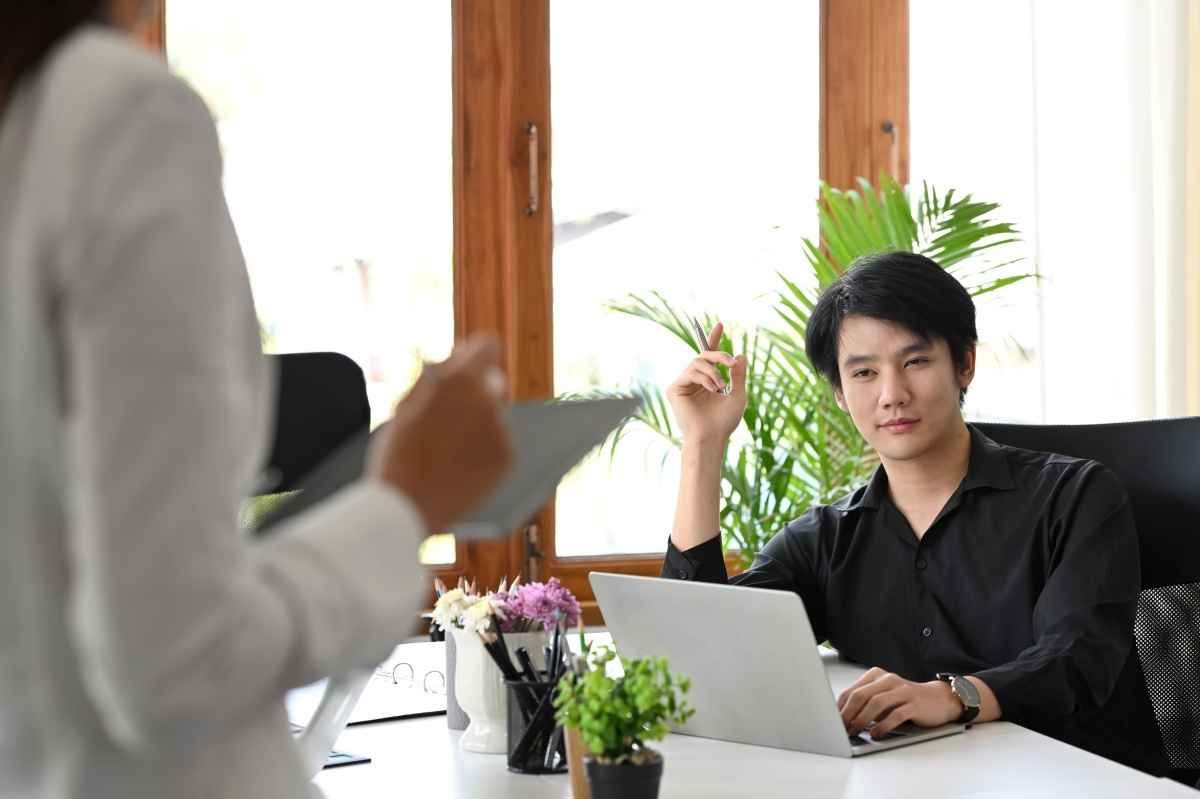 Ilustrasi seorang fresh graduate tampak serius saat menjalani interview IT support. (Sumber: Envato)