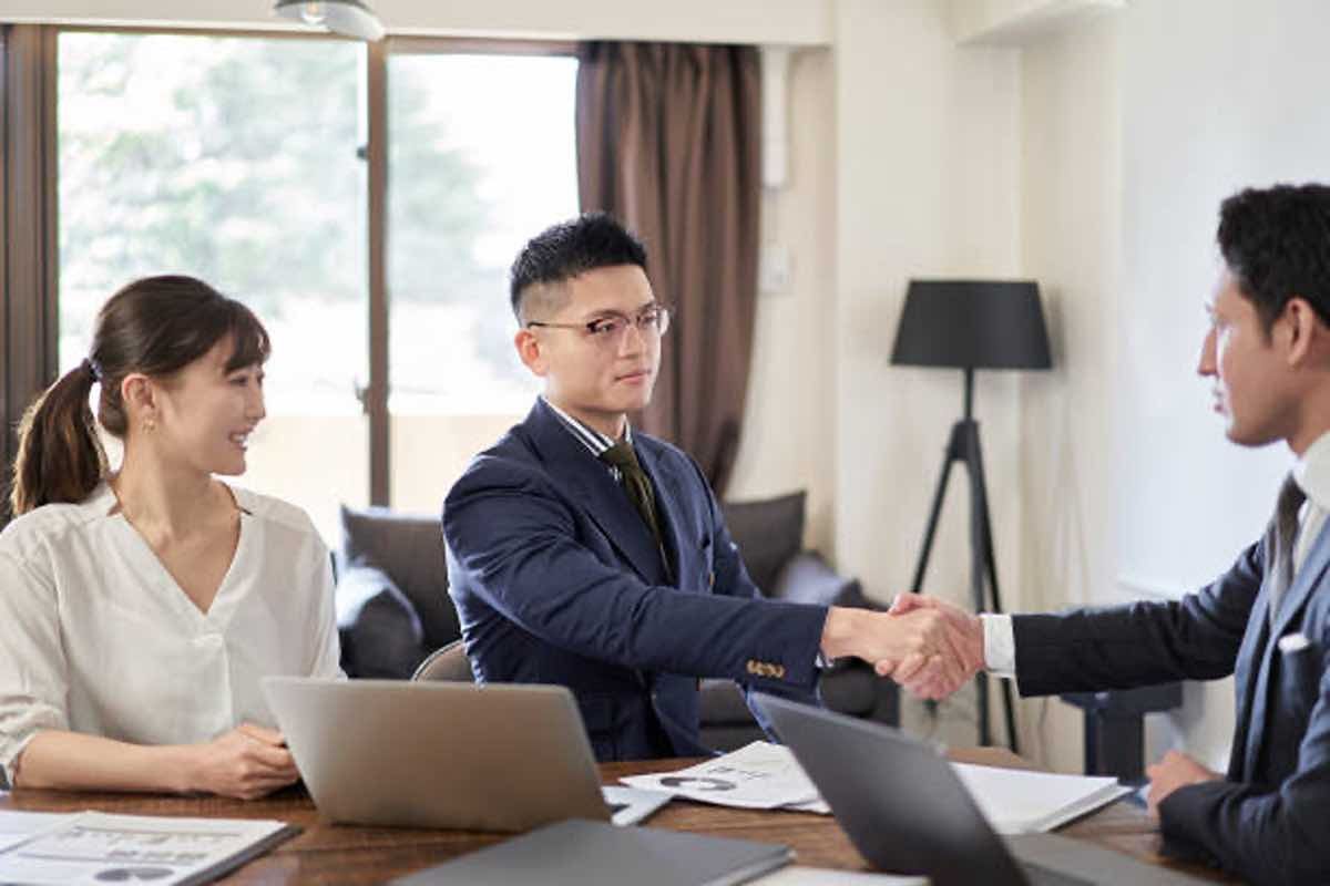 Ilustrasi seorang fresh graduate berjabat tangan dengan HRD perusahaan swasta setelah menjawab pertanyaan interview business development. (Sumber: Pexels)