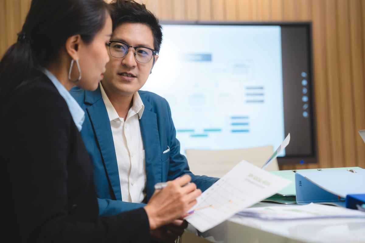 Ilustrasi dua orang karyawan perusahaan sedang berdiskusi soal business intelligence. (Sumber: Envato)