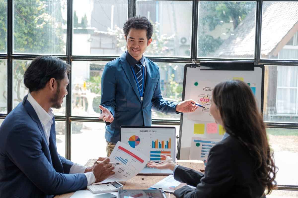 Ilustrasi tiga karyawan perusahaan swasta sedang membicarakan kisaran gaji business intelligence. (Sumber: Envato)