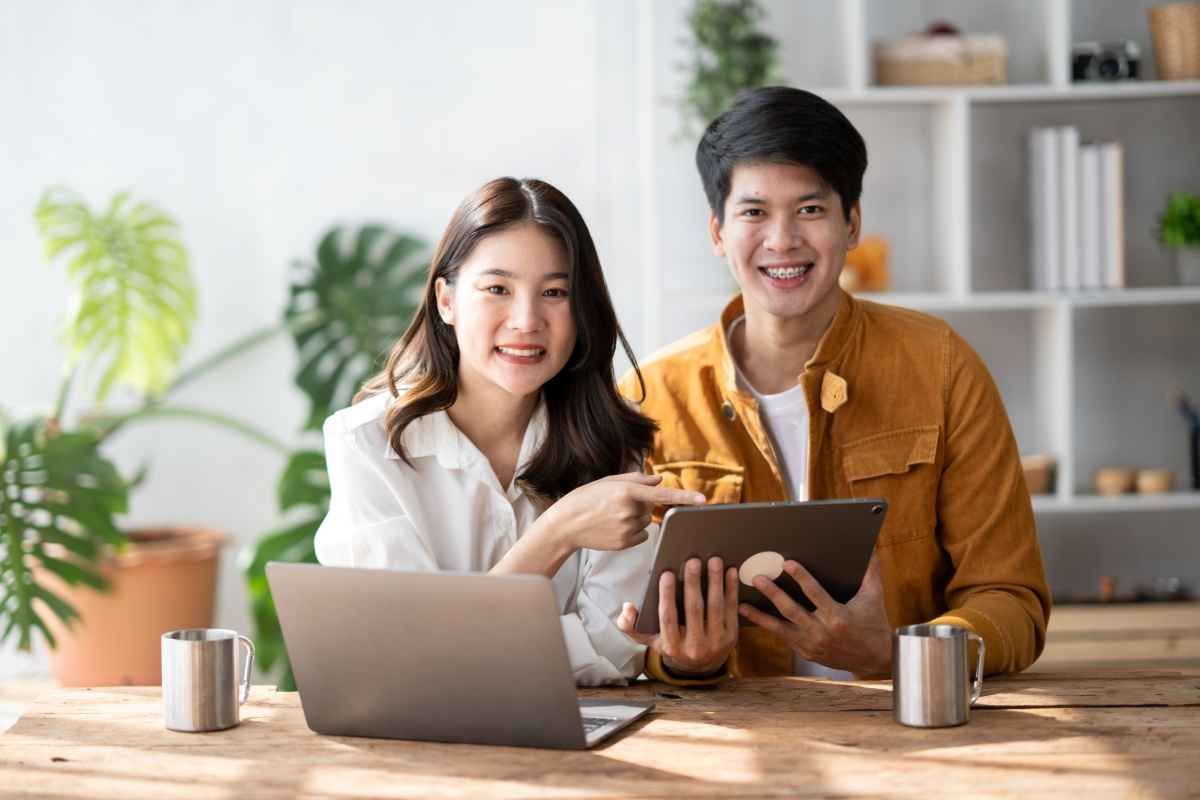 Ilustrasi dua orang fresh graduates tampak bahagia setelah selesai mencari kerja online. (Sumber: Envato)