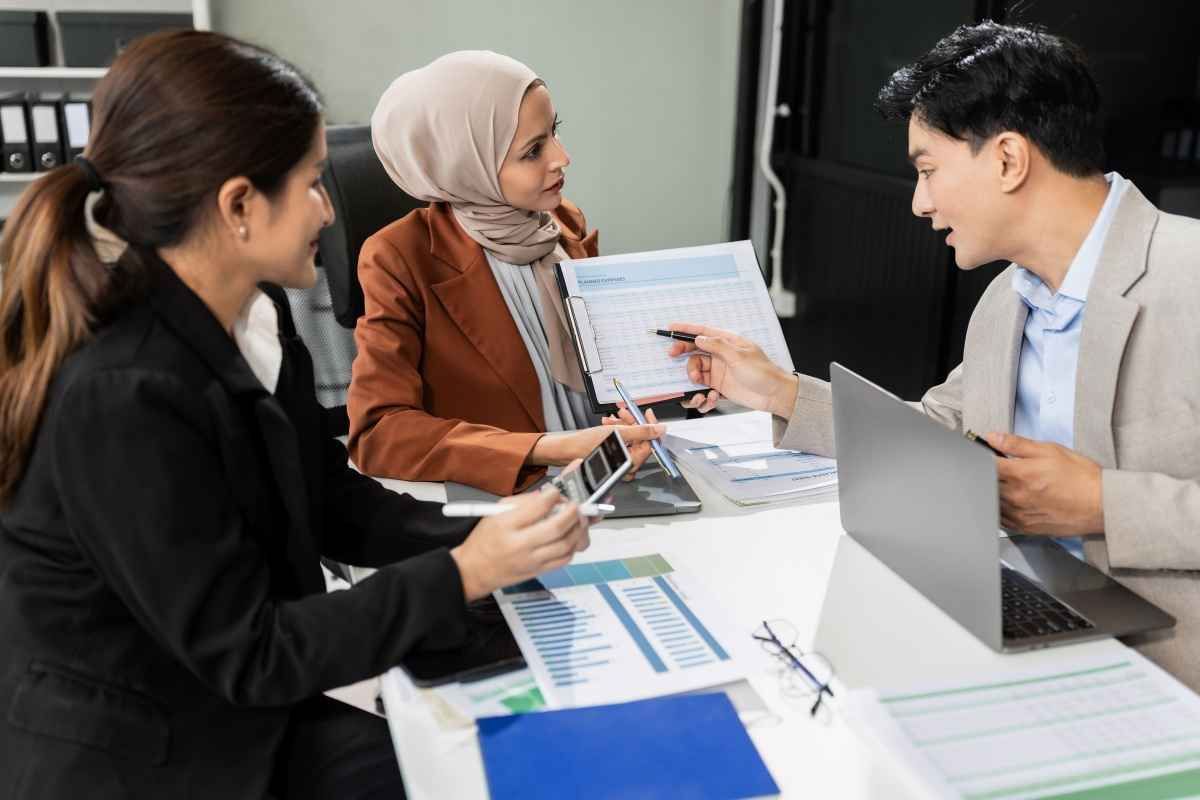 Ilustrasi tiga orang anggota divisi marketing perusahaan swasta sedang menyusun report kinerja. (Sumber: Envato)
