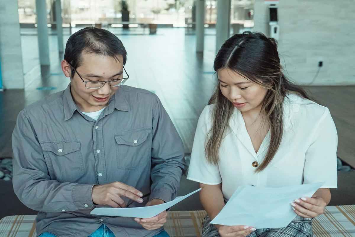 Ilustrasi dua orang pelamar kerja sedang berdiskusi soal pertanyaan jebakan saat interview kerja. (Sumber: Envato)
