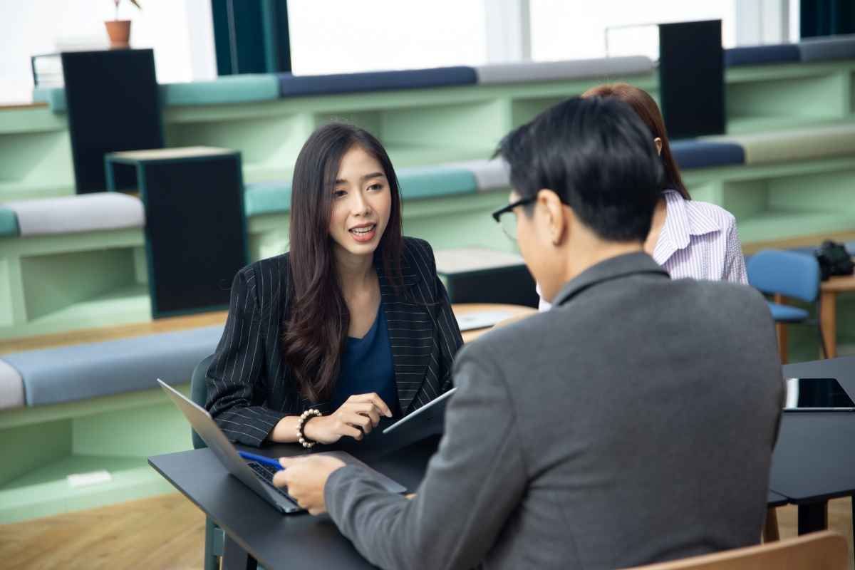 Ilustrasi seorang fresh graduate tampak serius saat menjawab pertanyaan interview IT support. (Sumber: Envato)