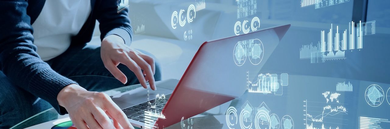 man on laptop with graphs and diagrams in the background