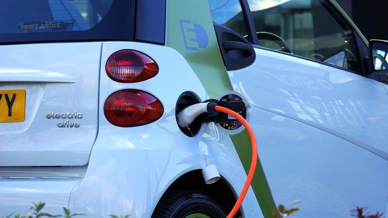 Kereta elektrik sedang dicas menggunakan kabel pengecas di stesen pengecasan awam.