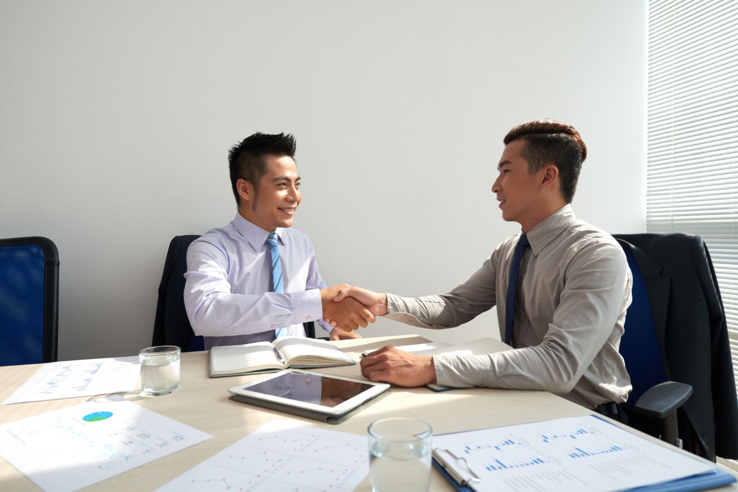 Seorang pelamar kerja bersalaman dengan HRD setelah menyelesaikan interview sales dengan baik. (Image by pressfoto on Freepik)