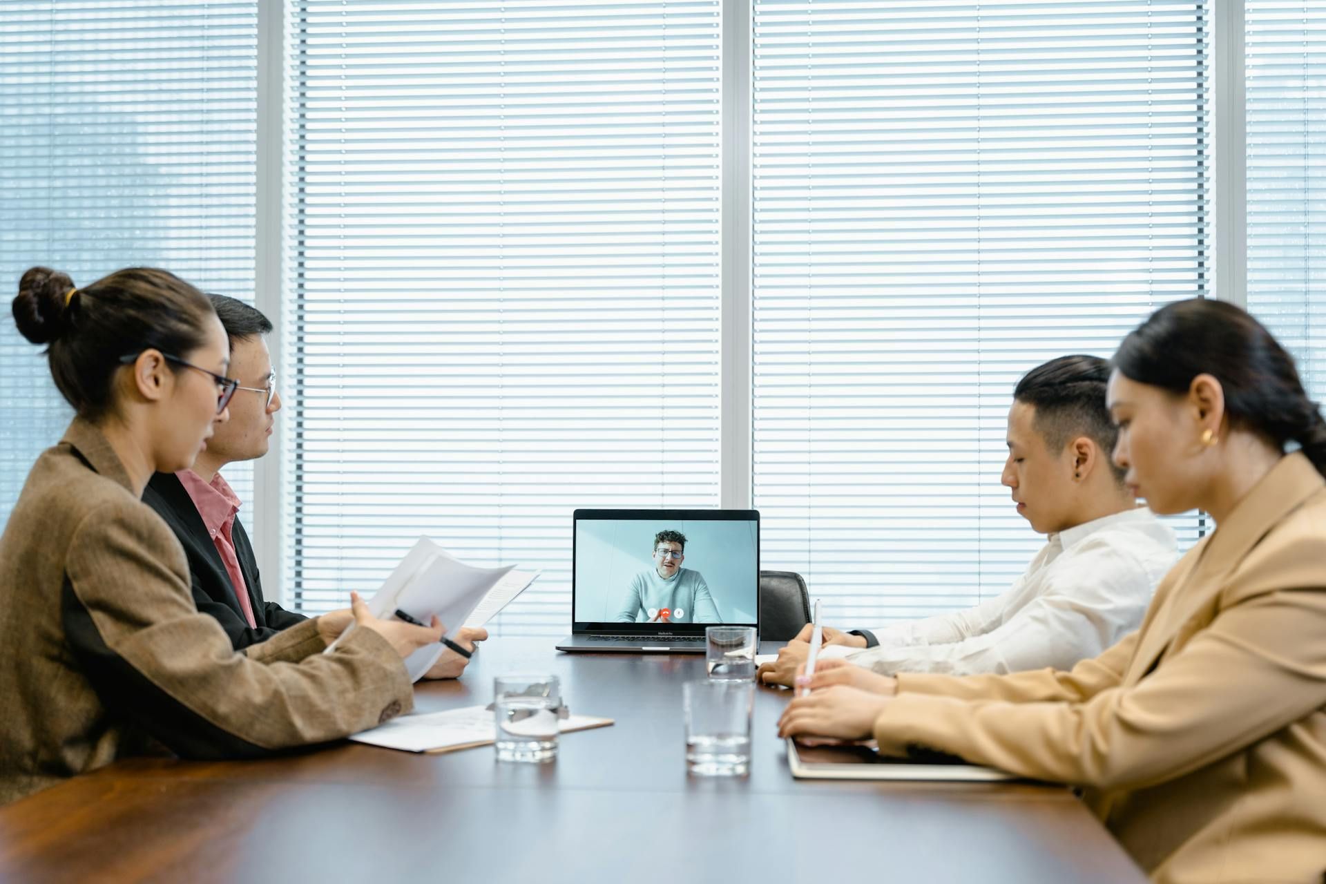 Panel of interviewers conducting a job interview with a candidate via video call.