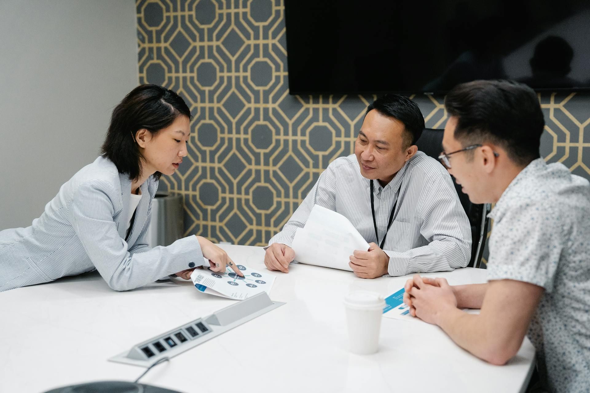 Team member presenting a visual report to colleagues during a collaborative business discussion.