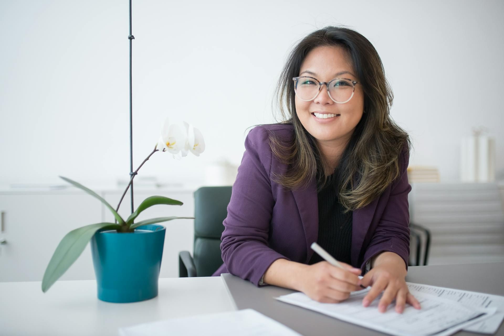Smiling employee comfortably working at her desk.