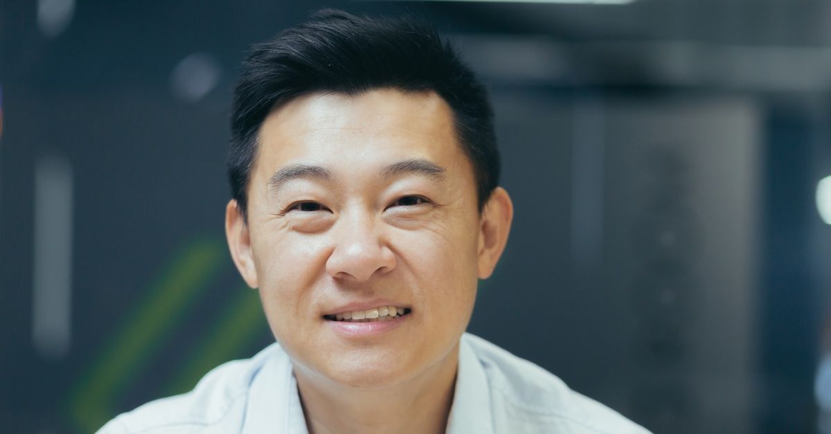 Man in a white shirt in front of a blue background
