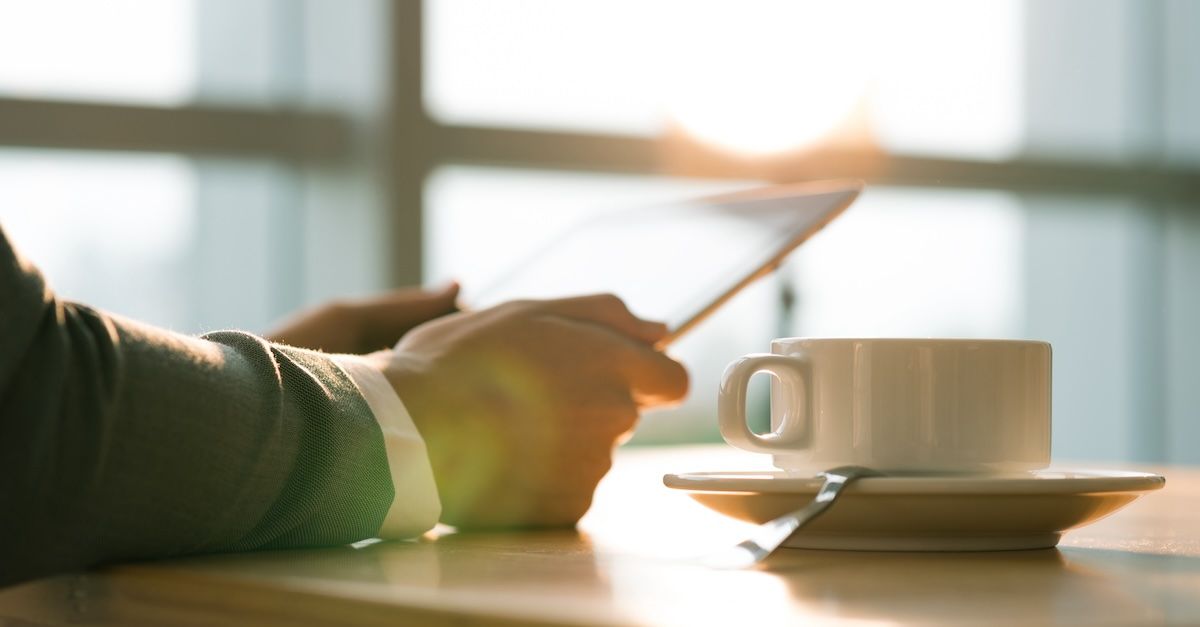 Man with a tablet and coffee in the morning