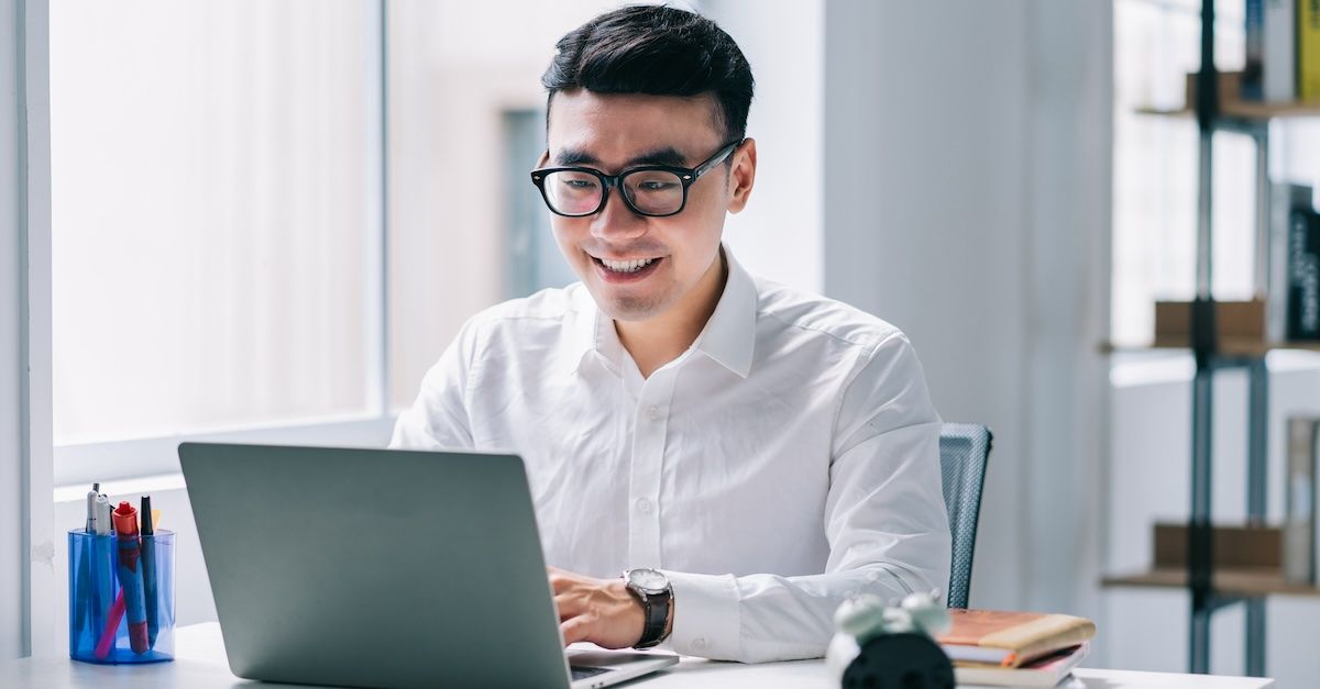 Man writing a request for leave email on a laptop