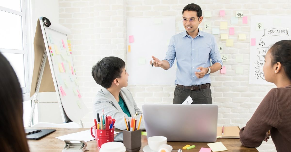 man teaching to three students