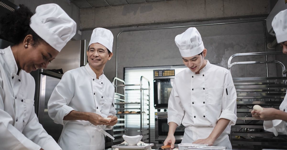 three chefs working in a kitchen