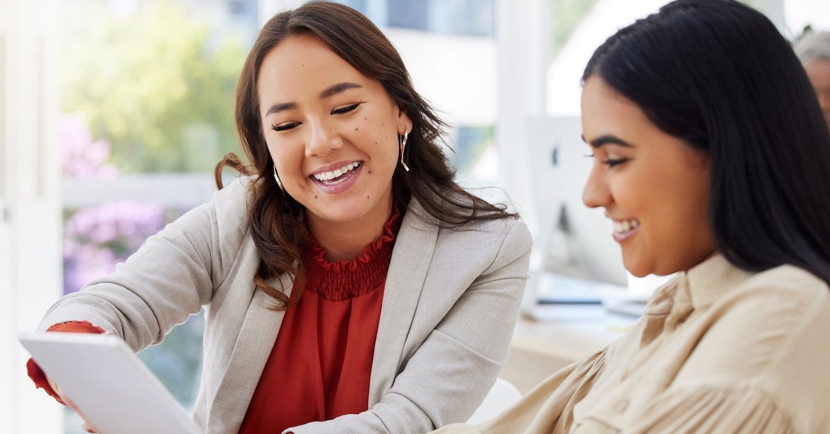 two women looking at tablet