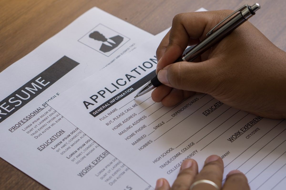 Ilustrasi seorang fresh graduate sedang menulis application letter atau surat lamaran kerja. (Sumber: Envato)