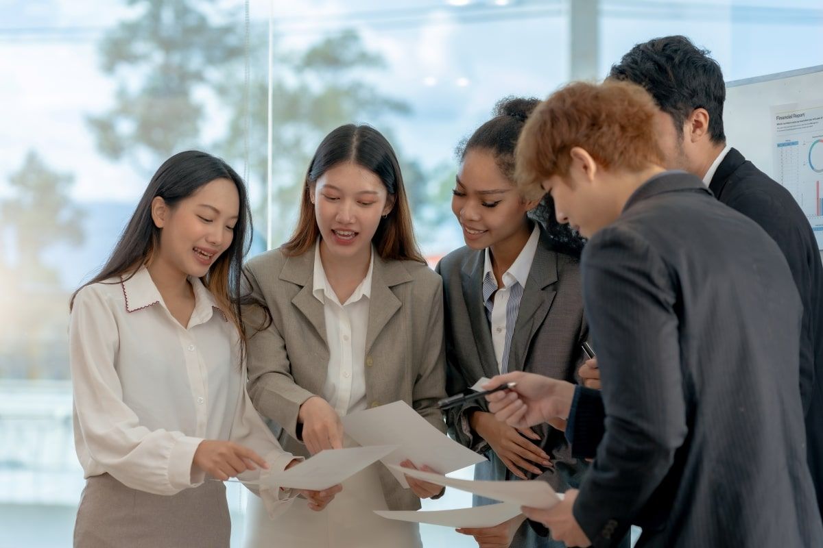 Ilustrasi lima orang pelamar kerja sedang berdiskusi soal strategi interview saat mengikuti job fair. (Sumber: Envato)