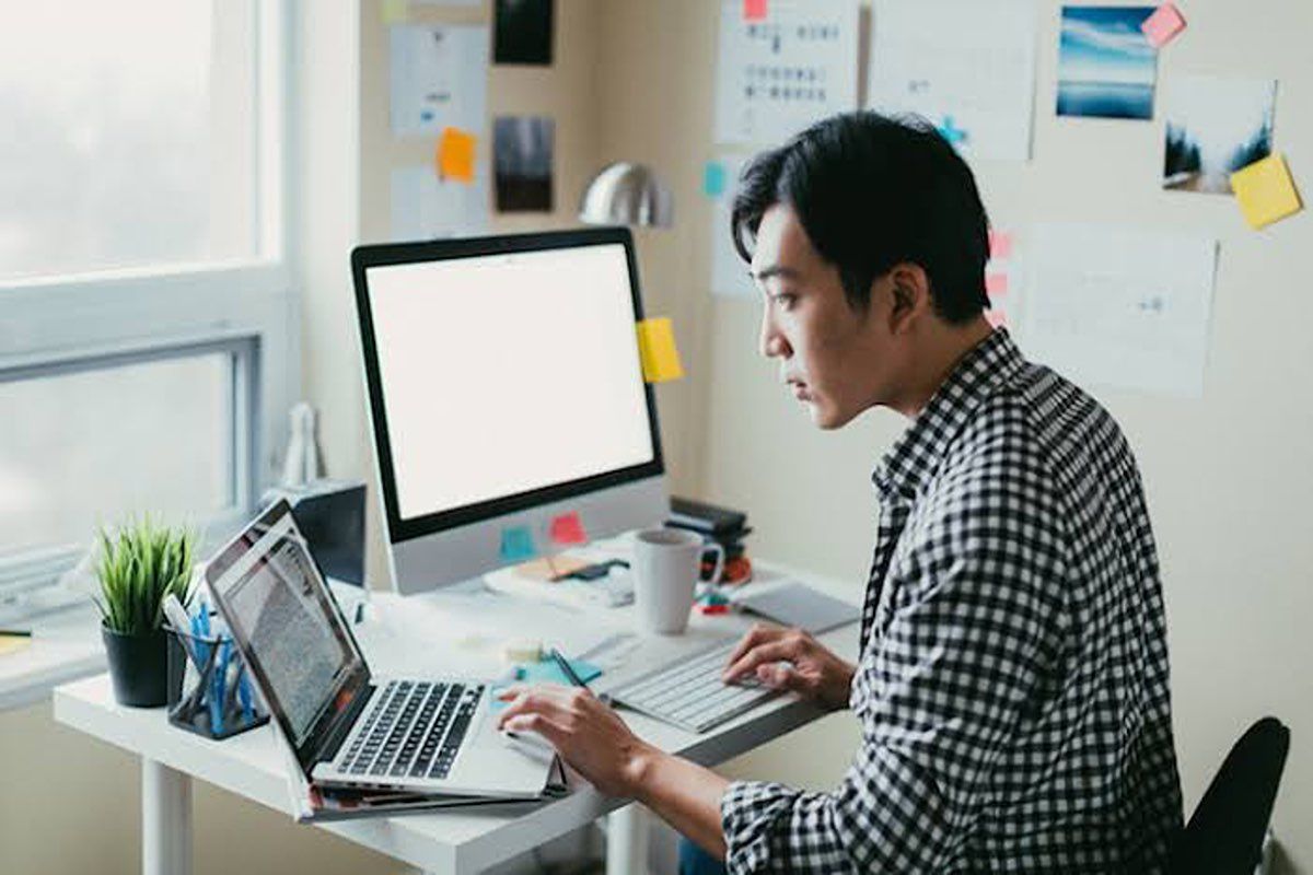 Seorang pria sedang mencari lowongan kerja online dari rumah.