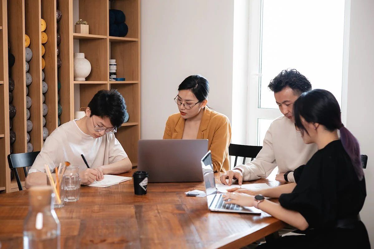 Empat orang karyawan startup sedang membicarakan sumber pendanaan.