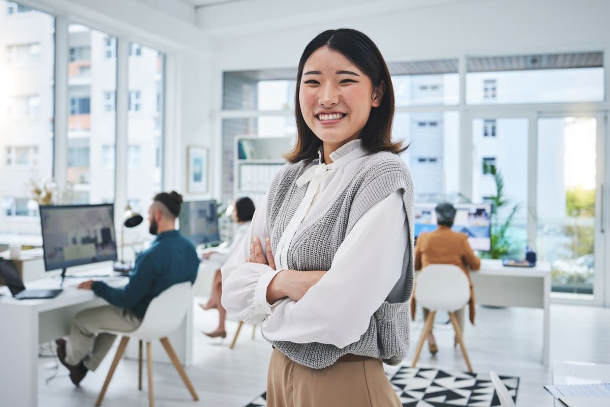 Seorang karyawan wanita yang punya kepribadian extrovert tersenyum di kantor.