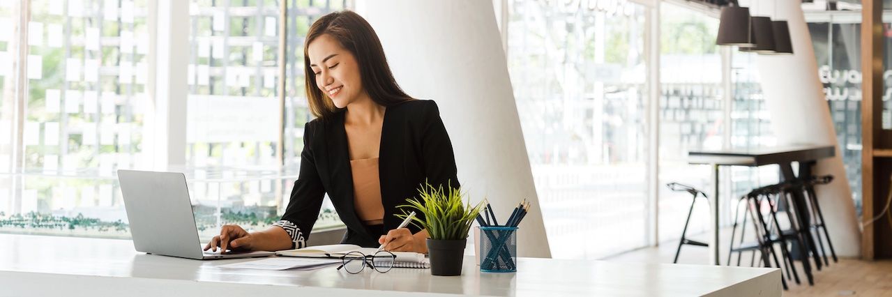 woman in office wearing a blazer working