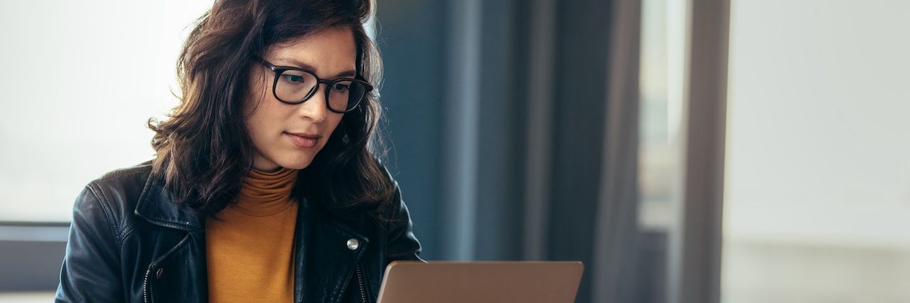 woman looking at laptop wearing a black jacket