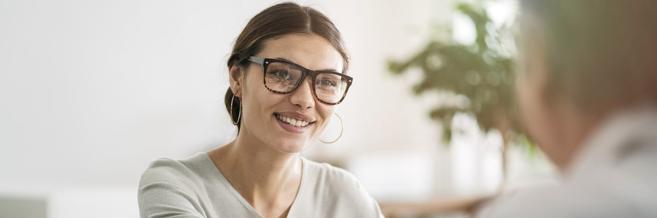 A woman smiling with blurred plants in the background