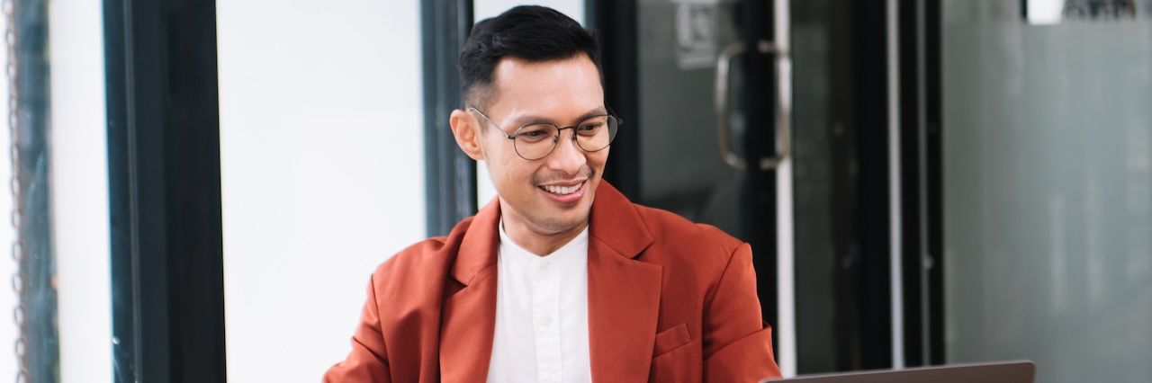 man working in a red blazer and white shirt