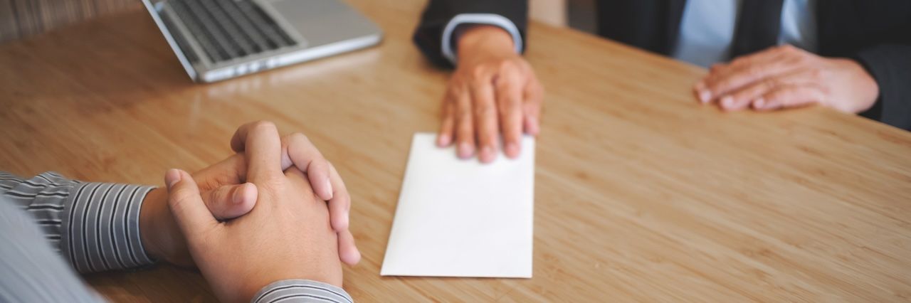 man handing a letter to boss at work