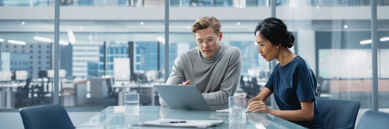 man and woman in office working together at a table