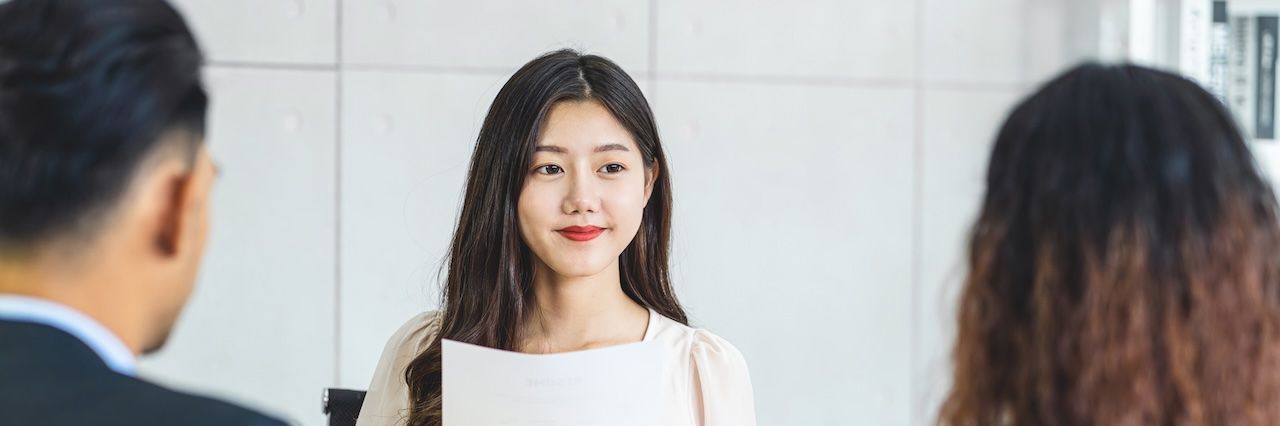 A woman in a group interview holding her resume