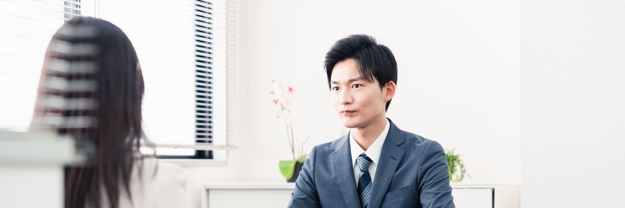 Man in a suit during an interview by a woman