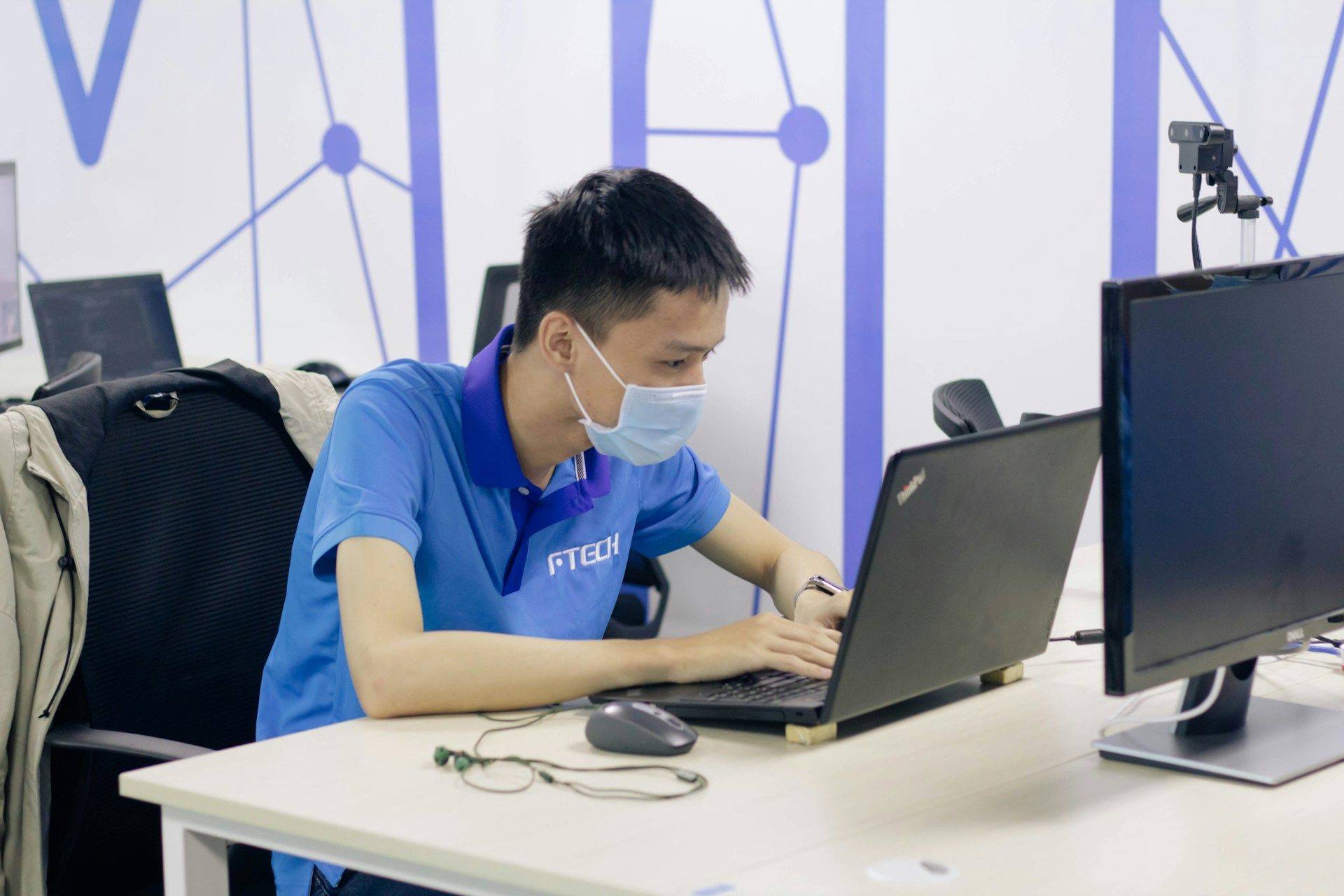 Seorang lelaki berpakaian kasual sedang menaip di laptop.
