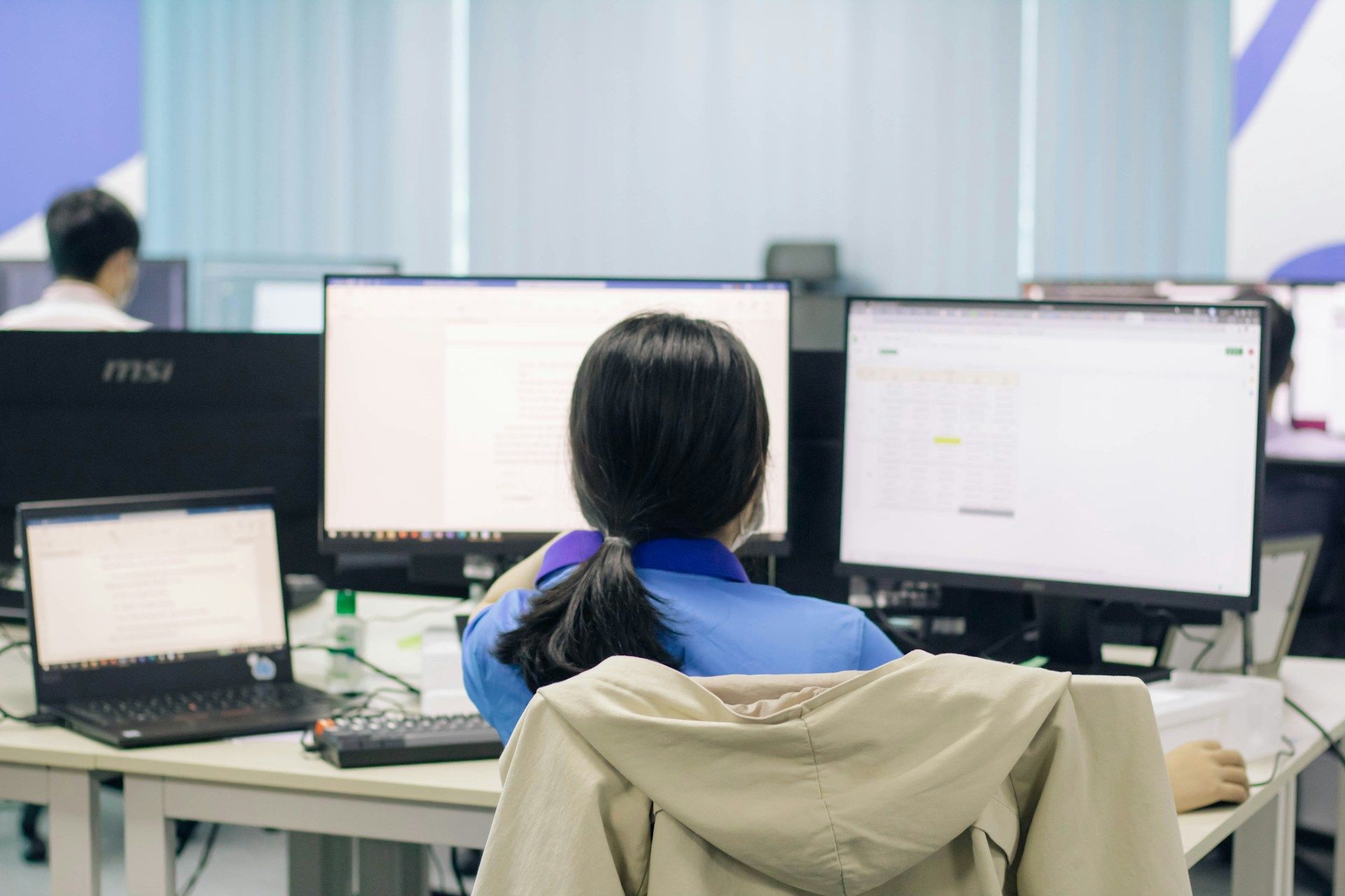 Seorang kerani perempuan menyusun data di pejabat.