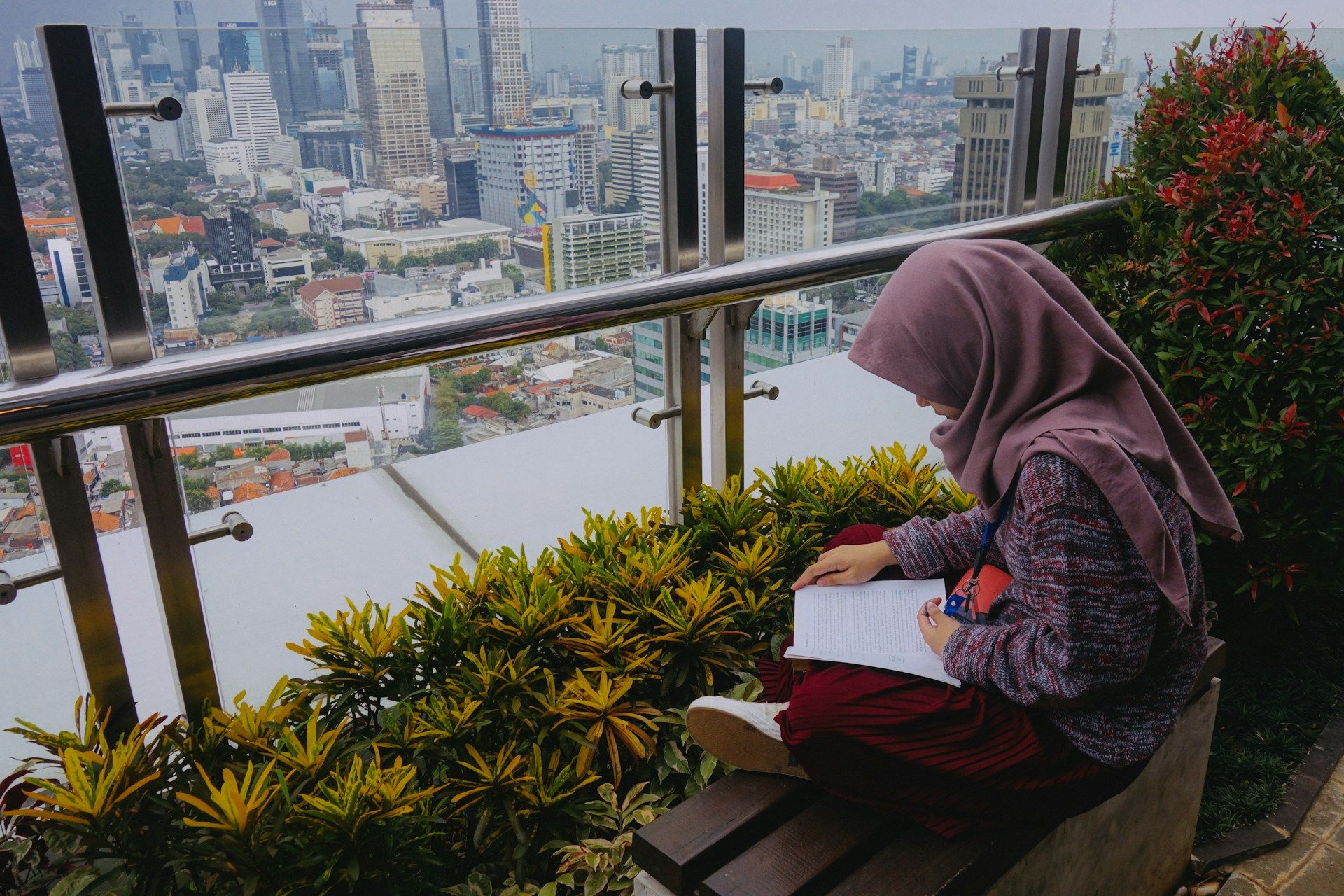 Seorang pekerja perempuan mengulangkaji pelajaran di balkoni tempat kerjanya.