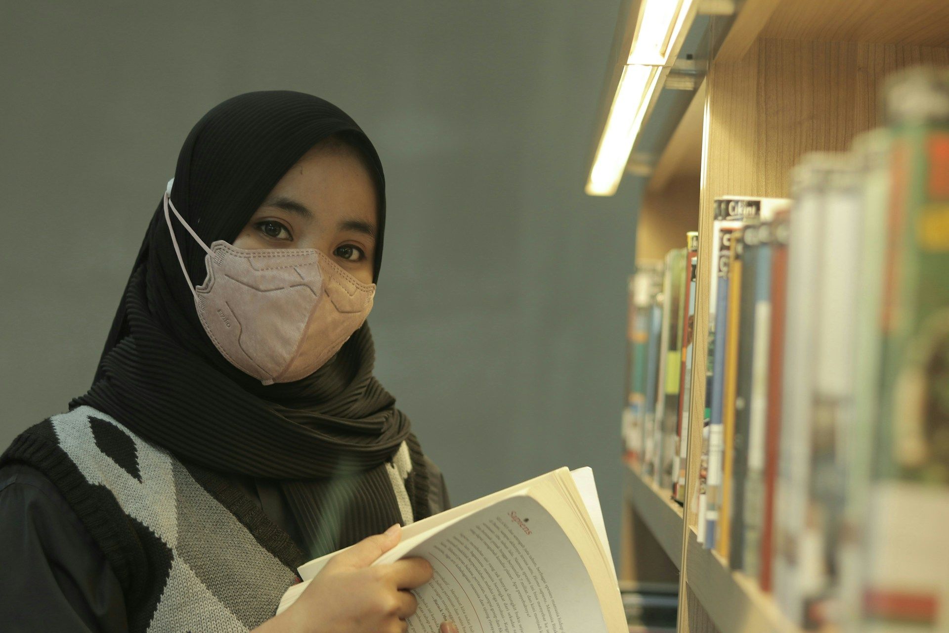 Seorang pelajar mencari buku untuk kajian pelajarannya di perpustakaan.
