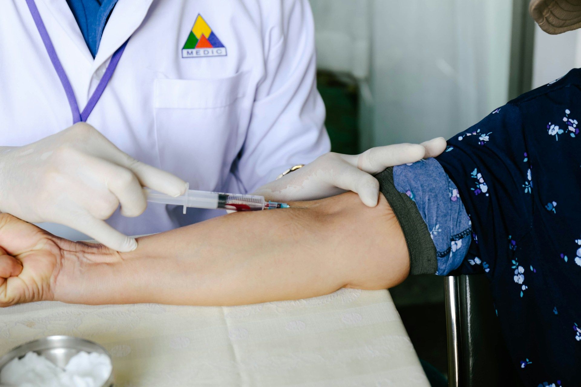 Seorang doktor sedang mengambil darah pesakit untuk pemeriksaan kesihatan.