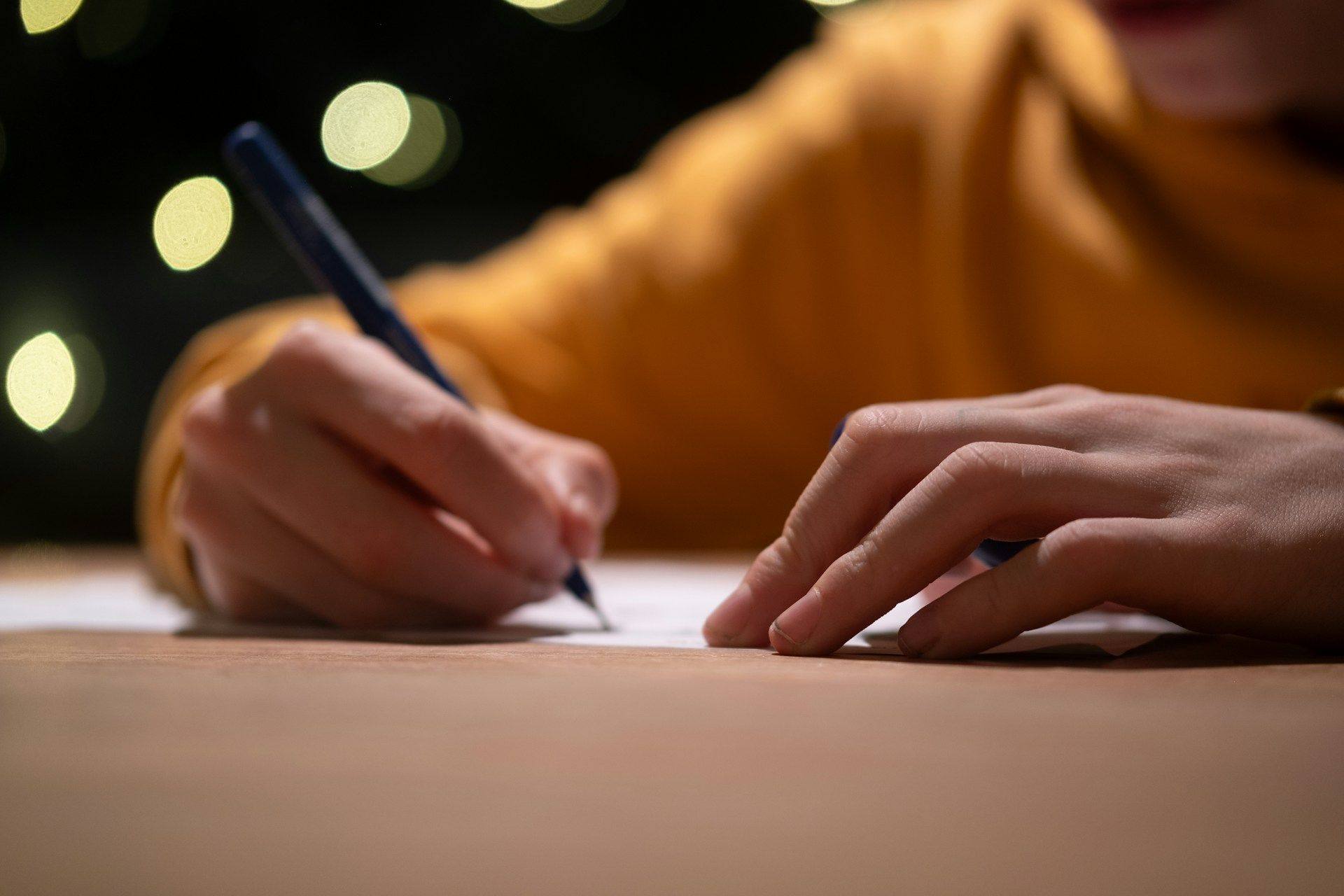 Individu sedang menulis surat tunjuk sebab untuk menjelaskan ketidakhadiran ke kursus.