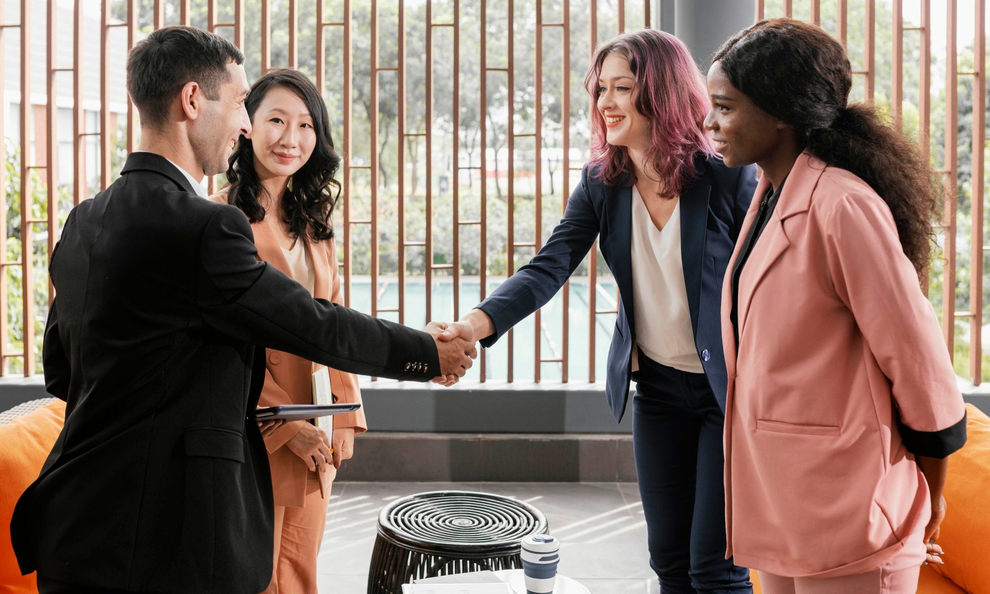 Professionals meeting in a casual business setting, discussing how to create a tagline and share new ideas for company branding.