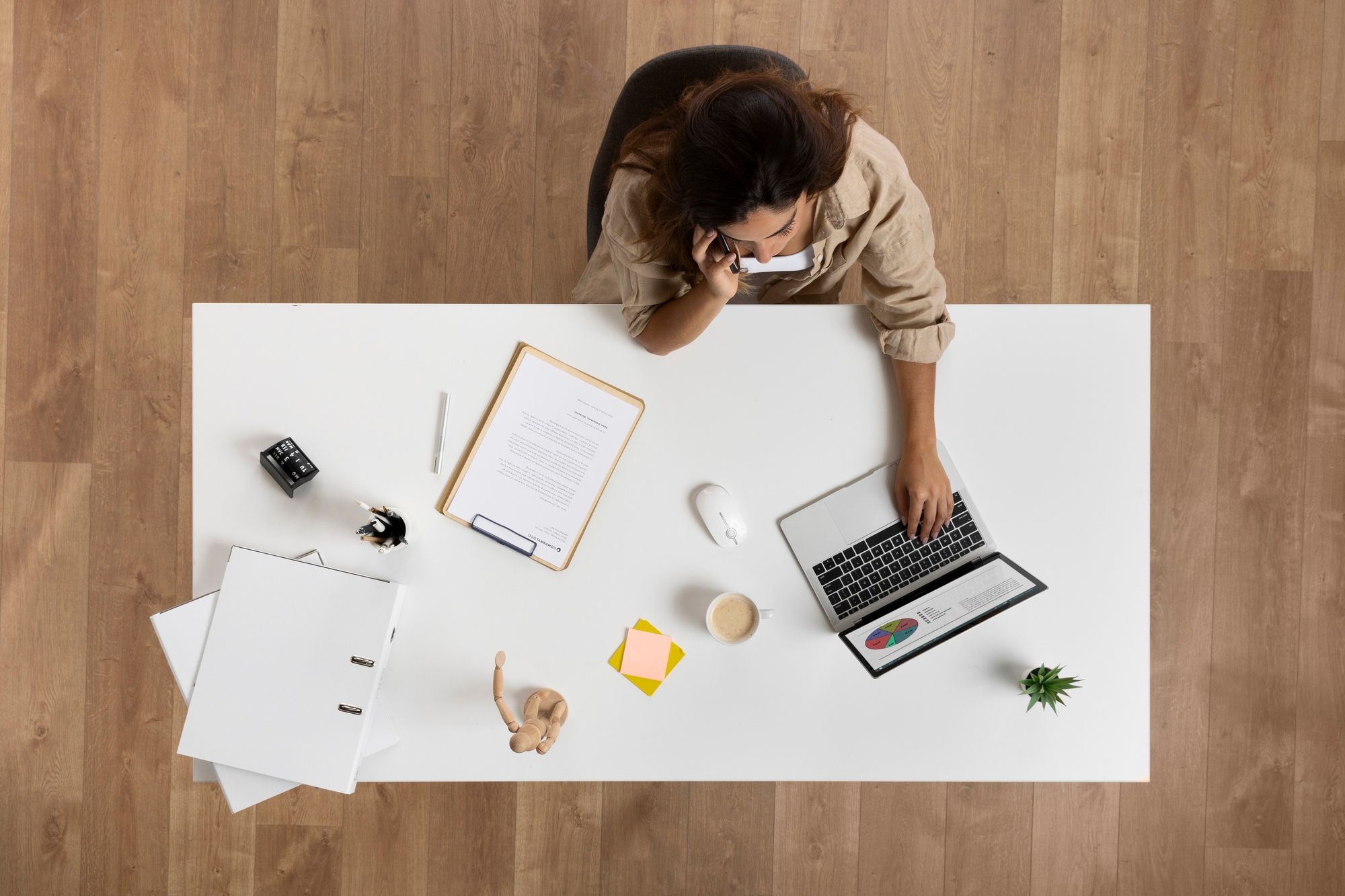 Overhead view of an executive drafting a resignation letter sample while contemplating her final day at work.
