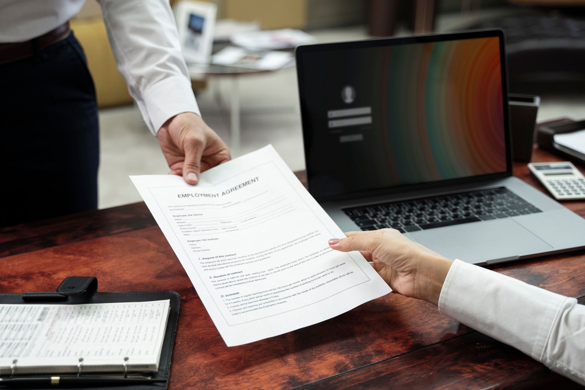 A person handing over a job offer in a Malaysian office, showing the result of a successful application letter.