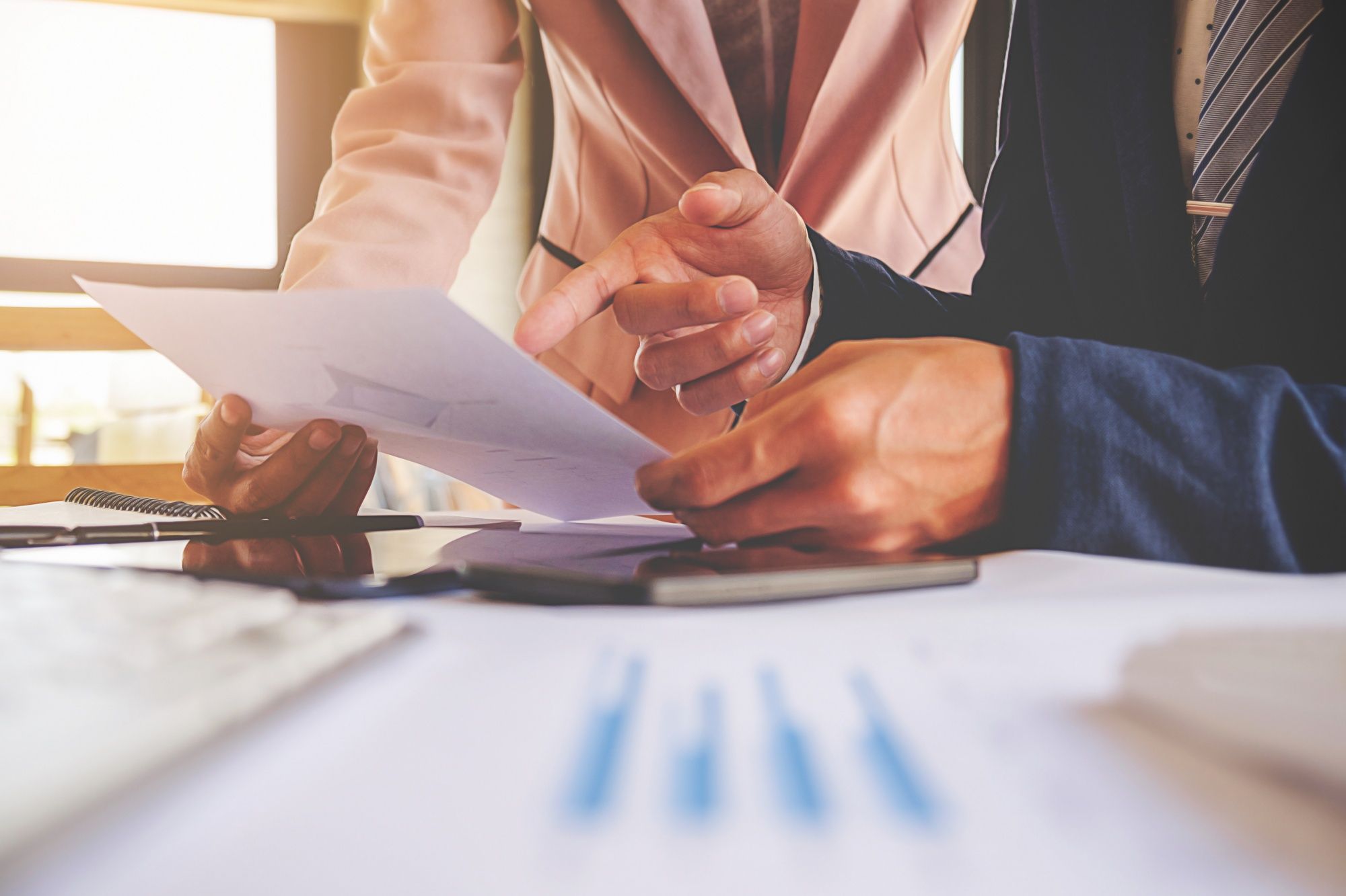 A professional female showing an accounting report to a male boss, understanding the difference between debit and credit