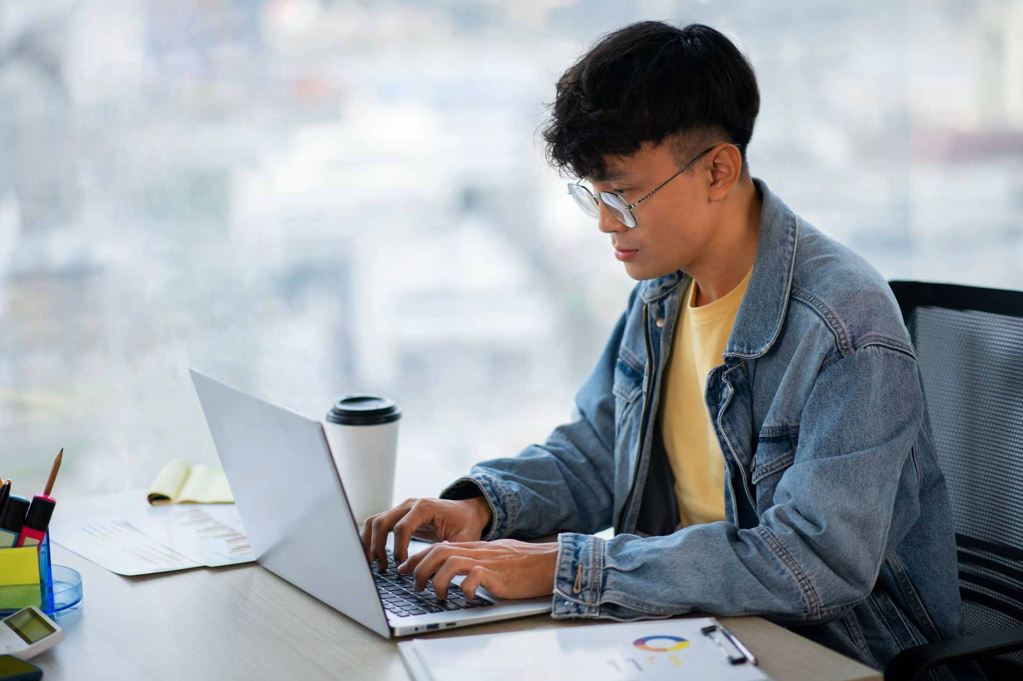 A man writing his own memos. He follows best practices such as knowing the target audience, adding a subject line, writing an opening paragraph, and adding recommended actions.