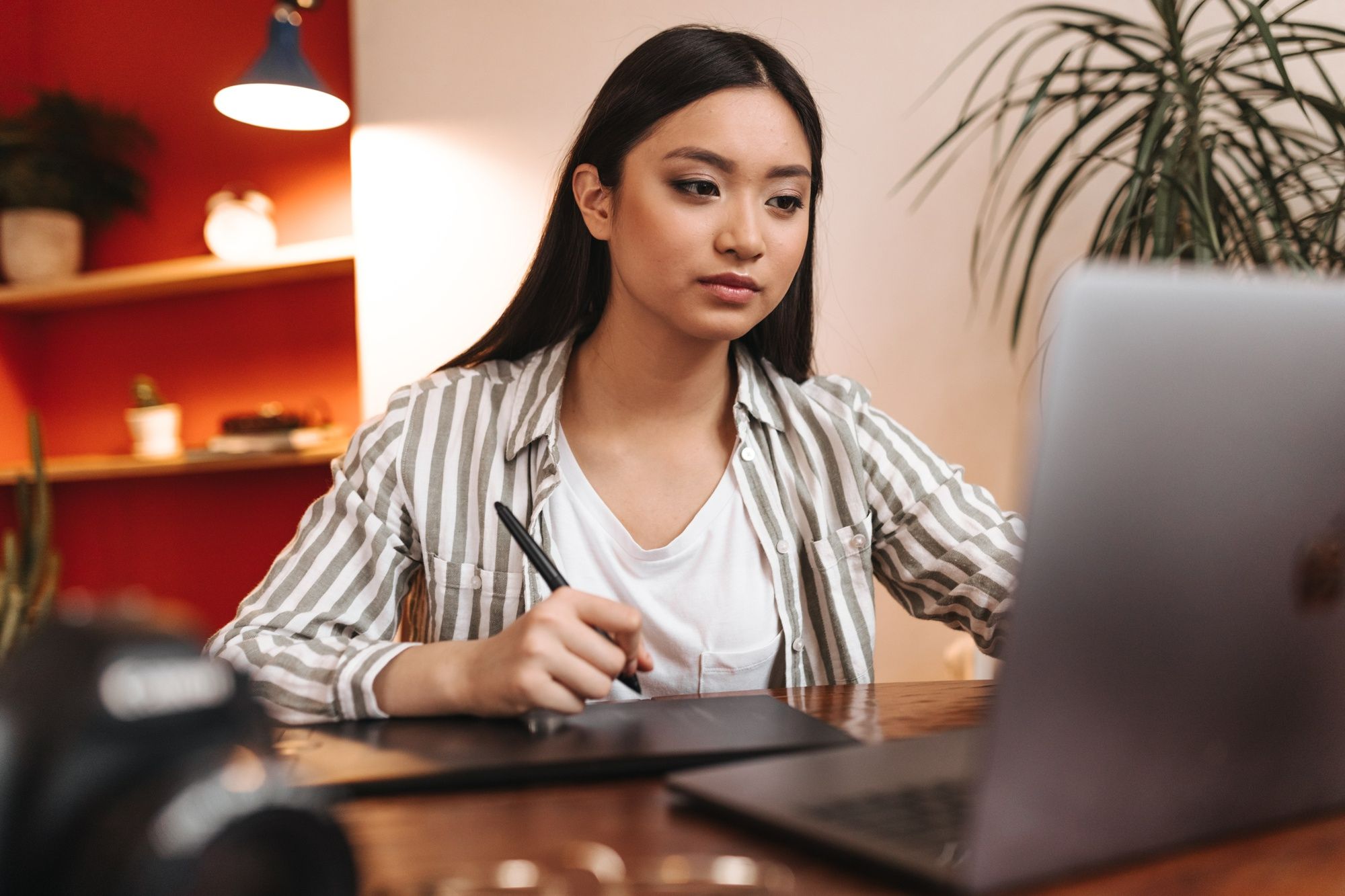 A young female job applicant thinking about how to write an Applicant Tracking System (ATS)-friendly resume