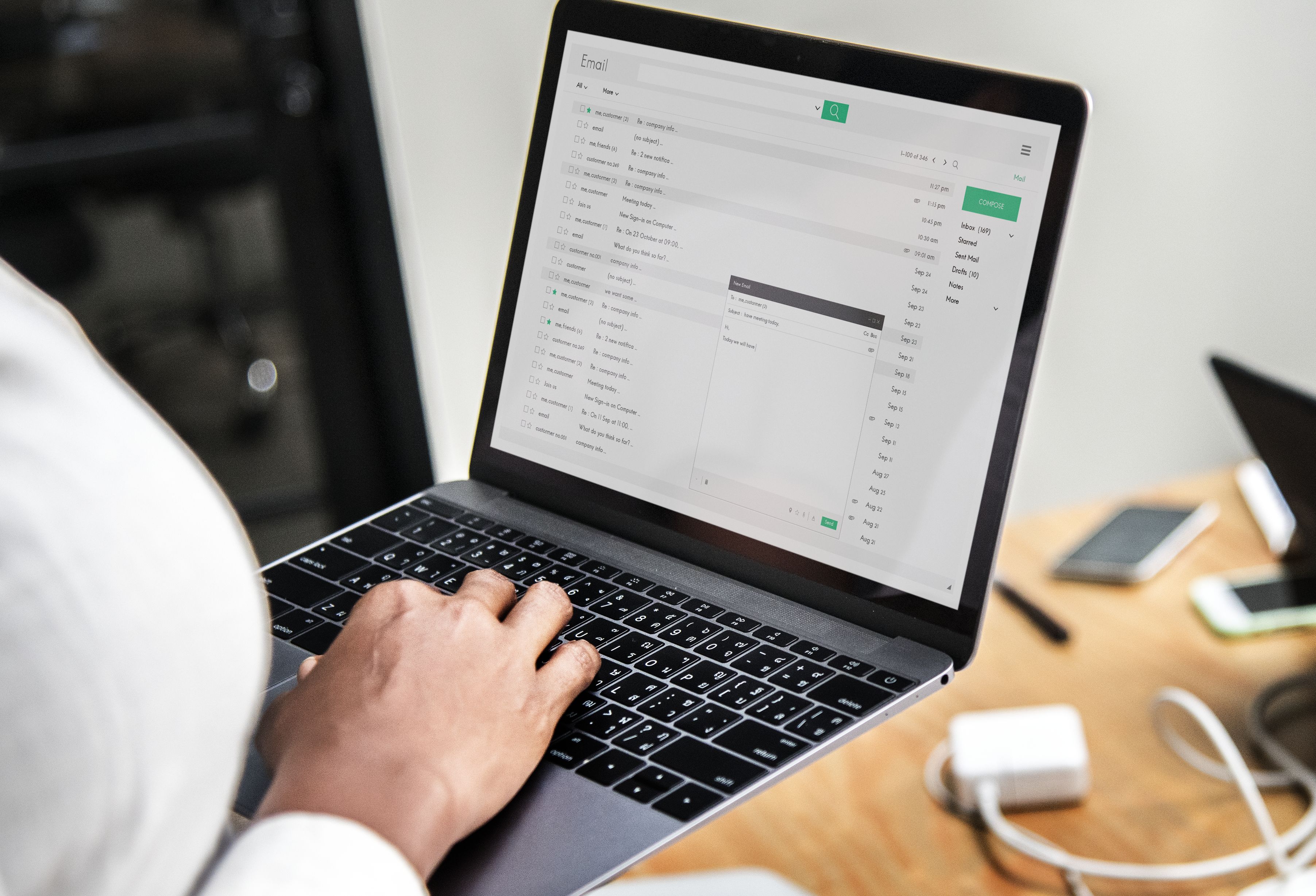 A female worker starting to write a professional email and looking through an example email