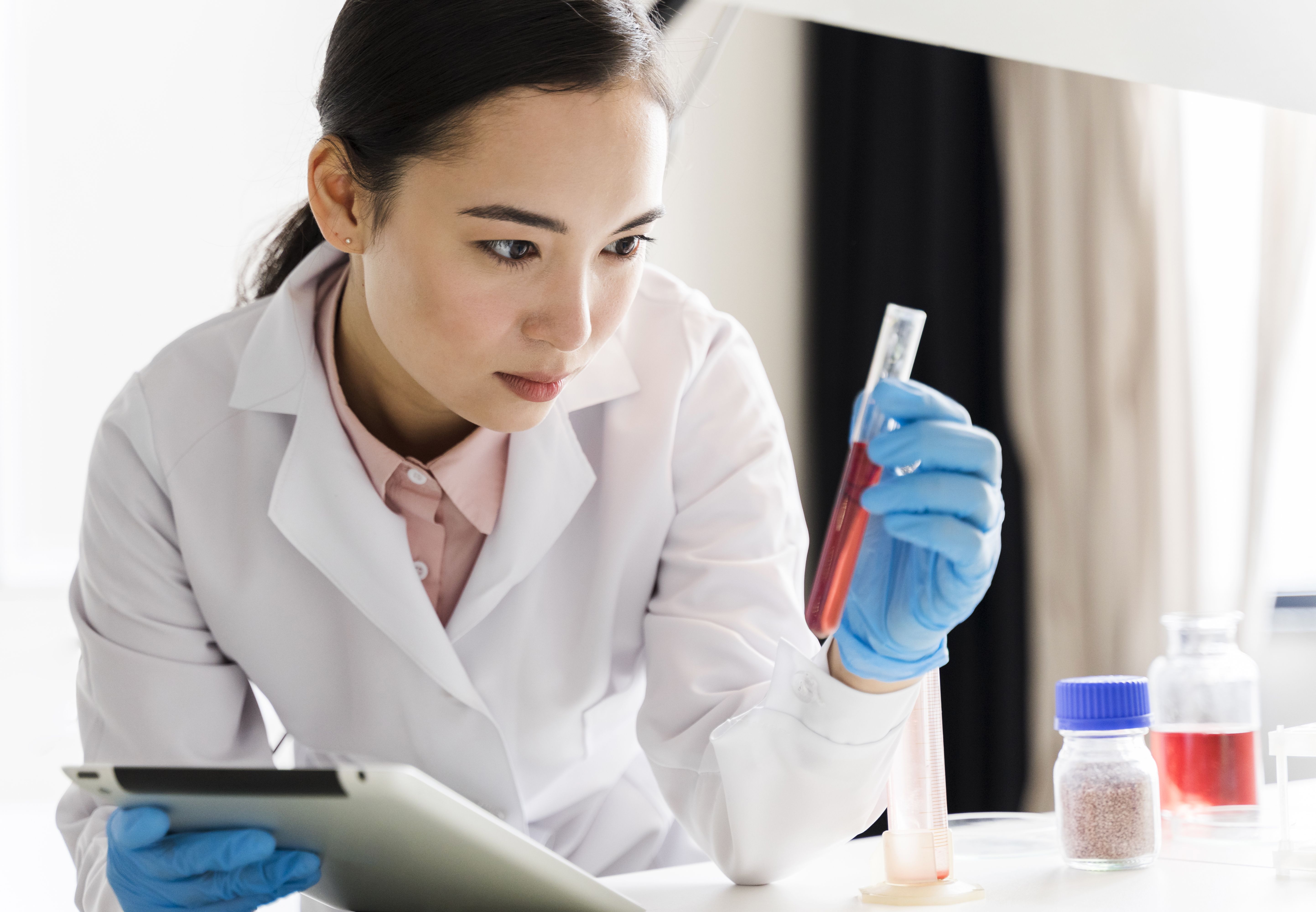 Female scientist in lab coat, an example of a high-level professional position where curriculum vitae tend to be comprehensive.