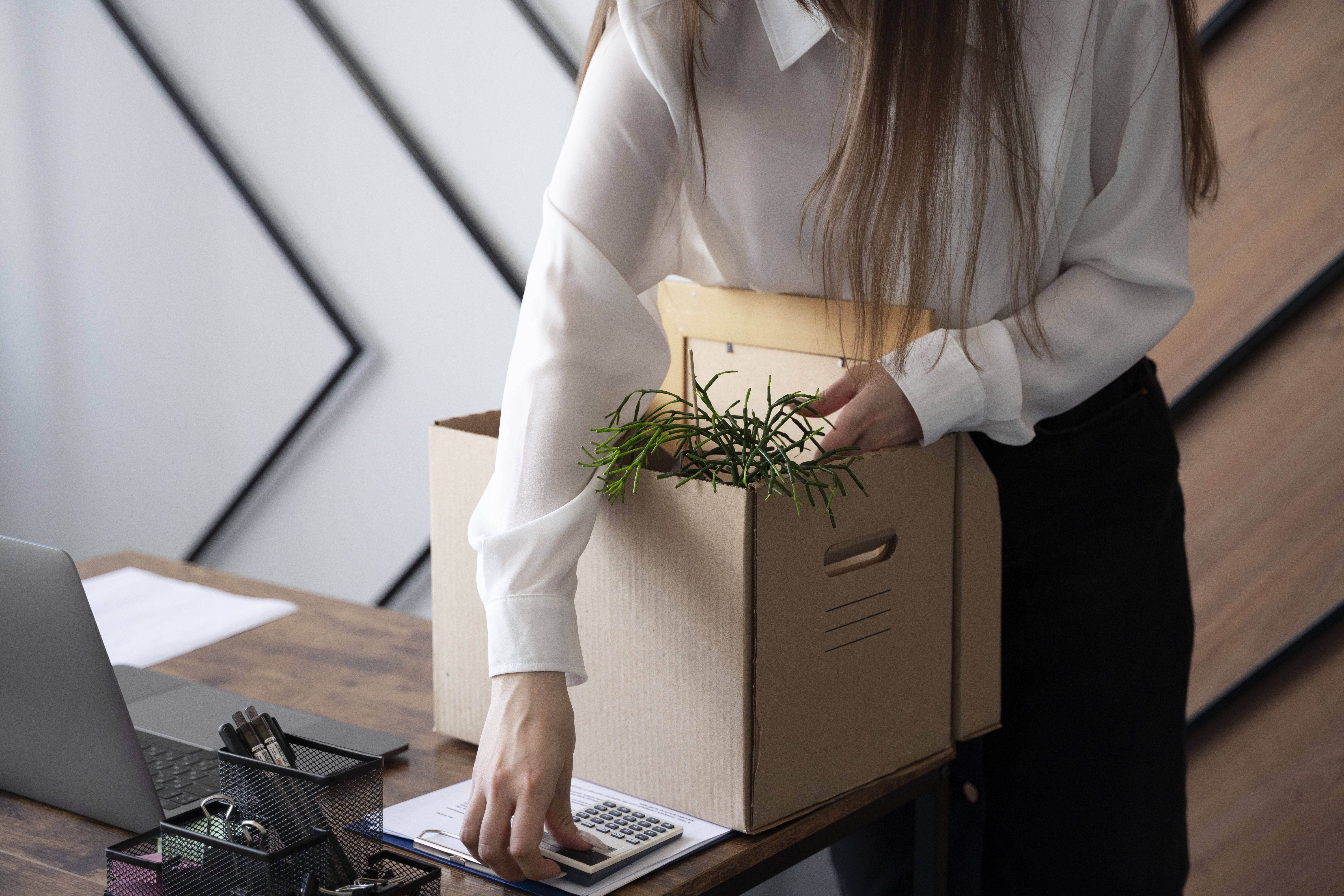 A woman packs her things at the office carefully after resigning from her job.