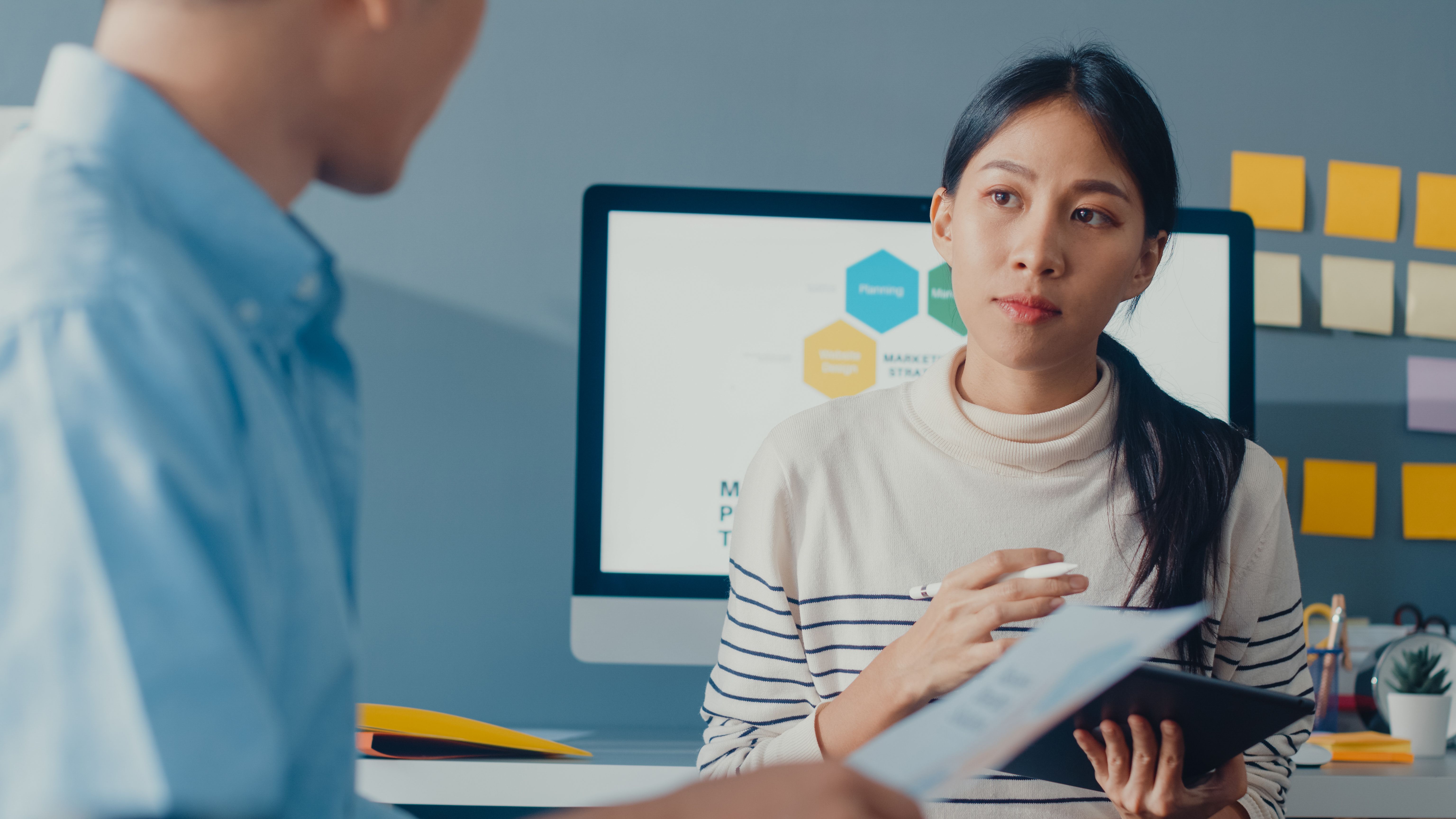 Professional listening to a discussion in a modern office, in a scenario relevant to weaknesses job interview examples.